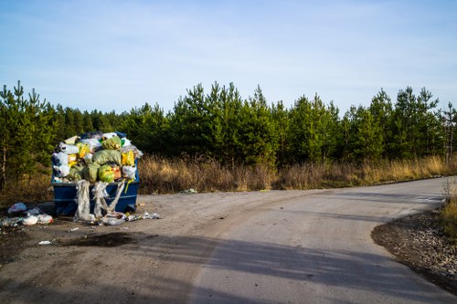 Workers separating wood, metal and soil during a garden clearance